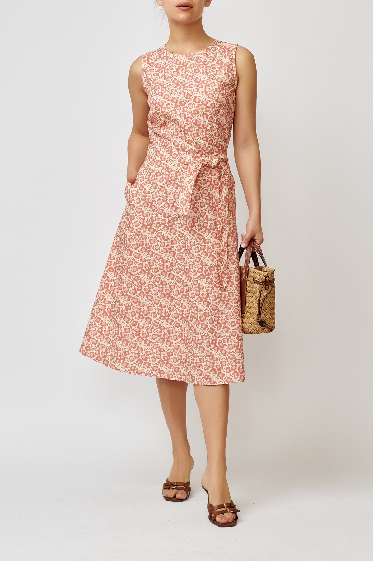 Sleeveless poplin dress with brick flowers on a cream background